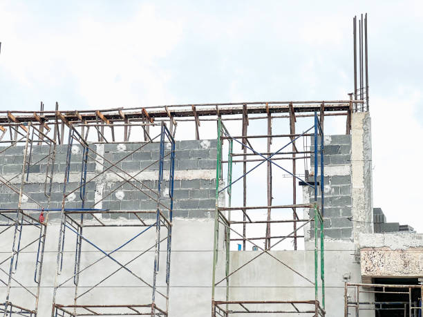 istock Building Construction Site with Scaffolding, Steel Structures, Material Piles, and Construction Equipment 2185877578