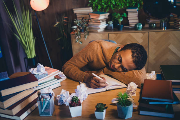istock Young student relaxing while studying at home surrounded by books and plants 2185878022