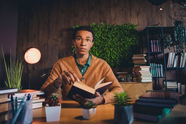 istock Young student studying with focus in cozy apartment surrounded by books and greenery 2185878051