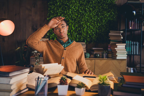 istock Young student studying in cozy home environment surrounded by books and natural light 2185878153