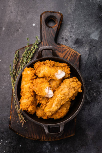 istock Fried chicken fillet tender strips. wooden background. top view 2185878400