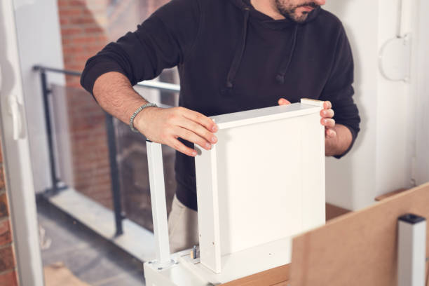 istock Man working and assembling furniture in a new apartment. 2185879357