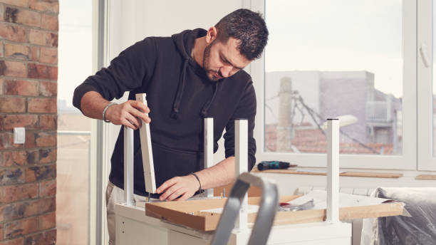 istock Man working and assembling furniture in a new apartment. 2185879384