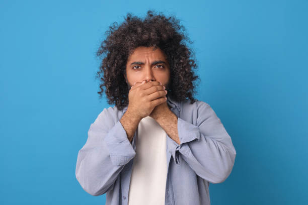 istock Surprised Man With Curly Hair Expressing Shock Against a Blue Background 2185880156