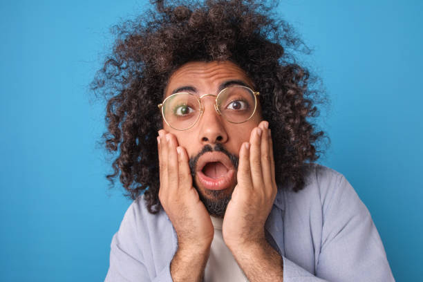 istock Surprised Expression of a Man With Curly Hair Against a Vibrant Backdrop 2185880157