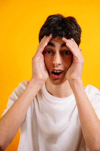 istock Stressed teen boy holding head in hands. 2185880543