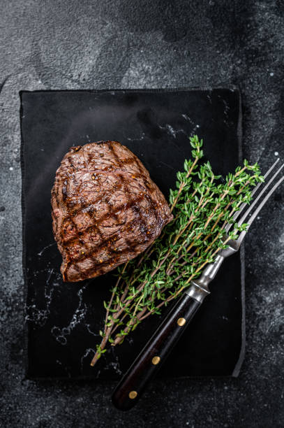 istock Grilled Rump steak with spices, cooked beef meat. Black background. Top view 2185880948