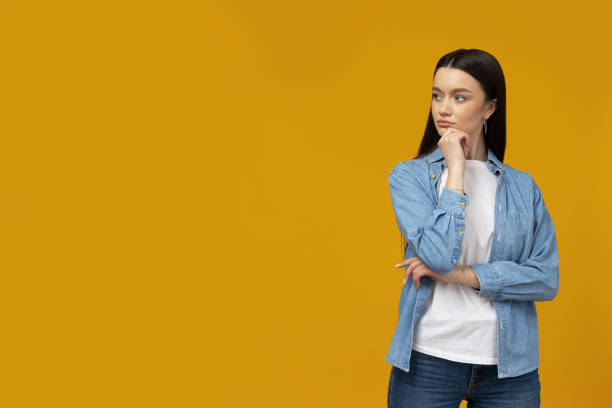 istock Beautiful young girl posing on a yellow background 2185881043
