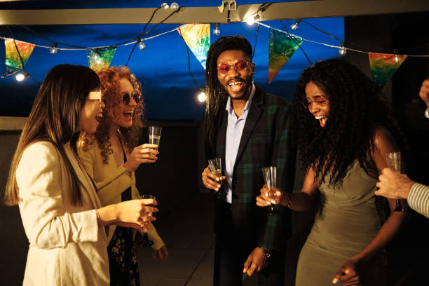 istock Multiethnic friends laughing and drinking at rooftop party 2185882905