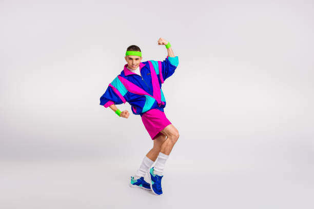 istock Young man in vibrant retro sportswear strikes a pose with energetic expression 2185884250