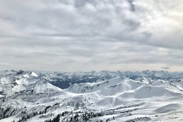 Amazing panoramic snow Mountain Range above valley fog layer. Rangiswanger Horn, Allgau, Bavaria, Germany.