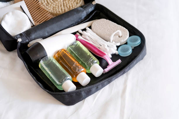 istock Travel cosmetics kit with bottles, brushes and cosmetics on bed 2185885403