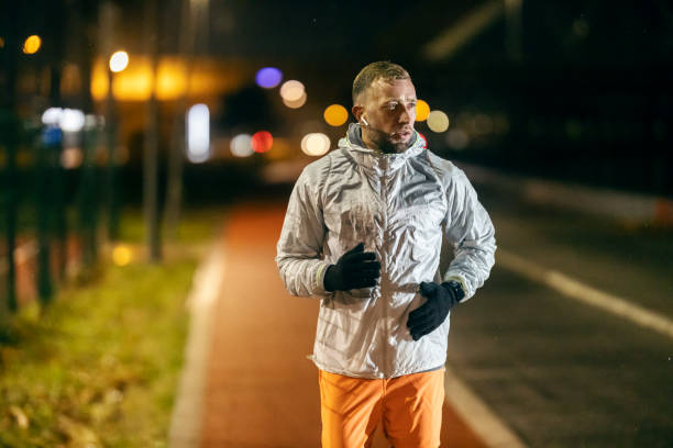 istock Fit night runner is running outdoors on city street. 2185886971