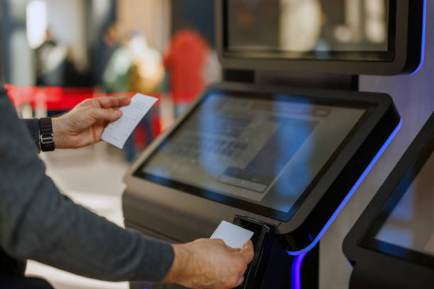 istock Man using ATM and holding suitcase at exchange office counter. 2185891184