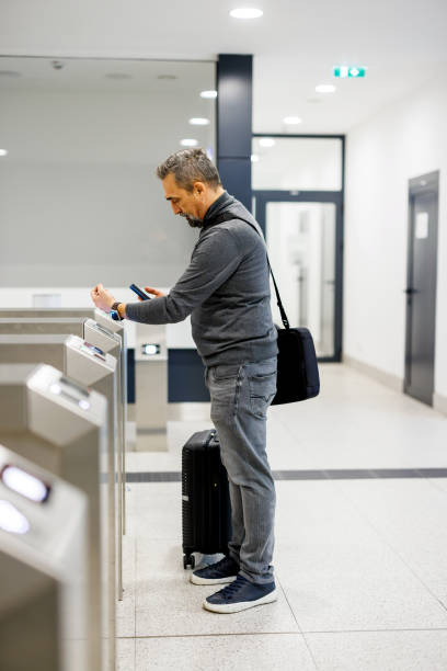 istock Traveler interacts at entry gate with card in hand, station 2185891314