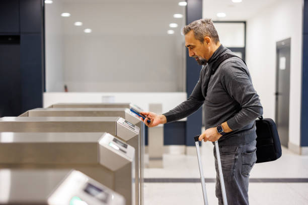 istock Man using phone at modern gate with suitcase and casual wear. 2185891324