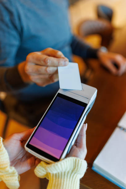istock Hand using credit card on a wireless payment device indoors 2185891365