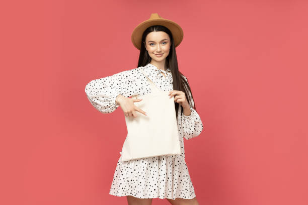 istock Smiling young woman in straw hat with bag 2185891411