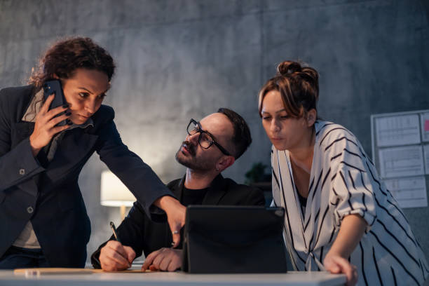 istock Business team working late using tablet and phone in office 2185894629