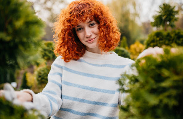 Portrait of a beautiful young redhead in a formal garden