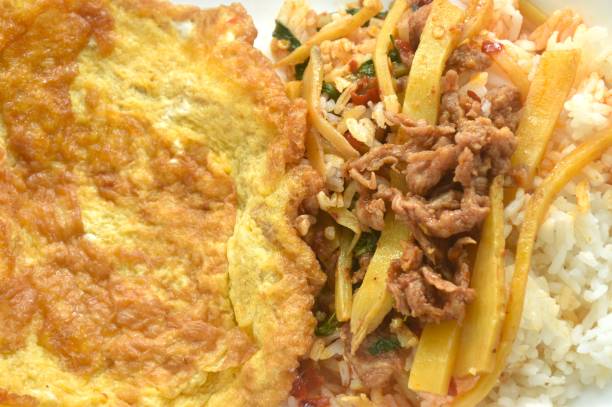 istock spicy stir fried bamboo shoot and slice beef meat with basil leaf topping Thai egg omelette on rice 2185897641