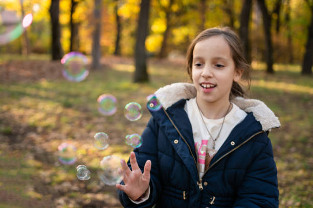 istock Girl playing whit bubbles in autumn park 2185897840