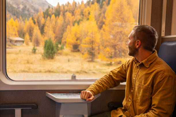 Man Admiring Autumn Landscape from Train Window