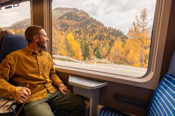 istock Man Admiring Autumn Landscape from Train Window 2185898335