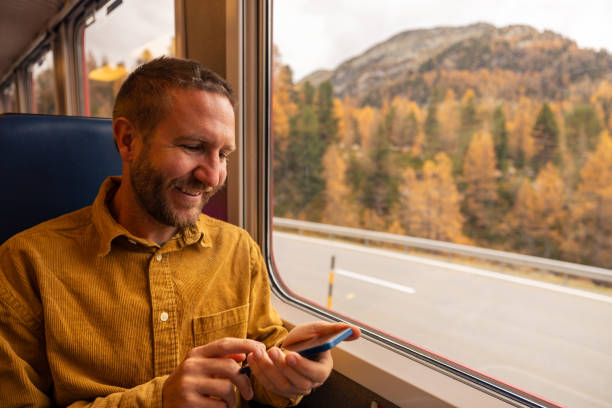 istock Smiling Traveler Using Smartphone on Scenic Train Ride 2185898374