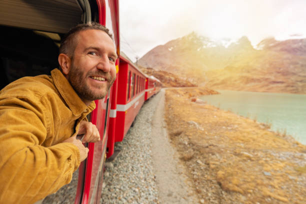 istock Man Enjoying Scenic Train Ride in Mountainous Landscape 2185898510