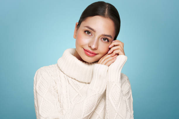 istock Young beautiful woman in a warm  white sweater 2185905791