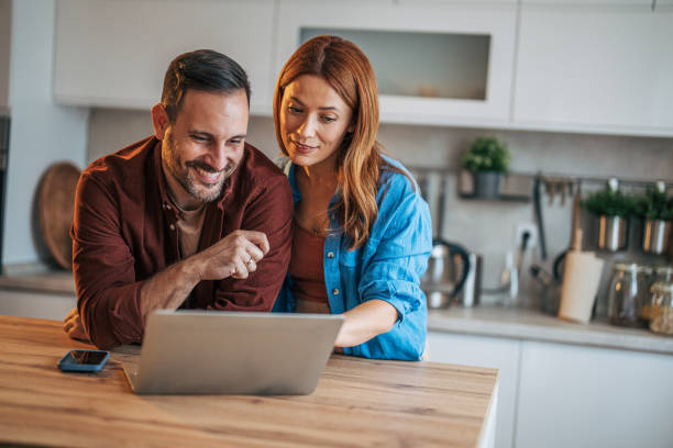 istock A cheerful husband and wife are standing in the kitchen. 2185906109