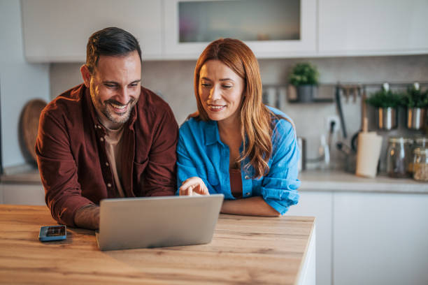 istock A cheerful husband and wife are standing in the kitchen. 2185906189