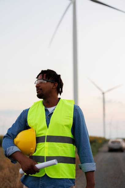 istock Young Engineer wearing uniform ,helmet hold document inspection work in wind turbine farms rotation to generate electricity energy 2185906262