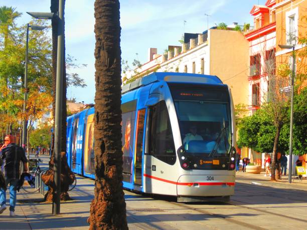 Seville, Spain - July 15, 2018: Electric tram on Constitution Avenue with iconic Seville Cathedral in background