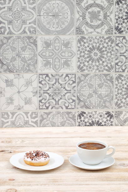 istock Enjoying fresh Morning Coffee with a delicious Donut on a decorative tile background 2185906805