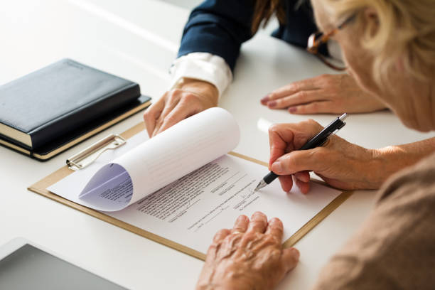 Senior woman signing the will with lawyer Female lawyer explaining the will to senior woman. Close up of hands, unrecognizable people. legal document stock pictures, royalty-free photos & images