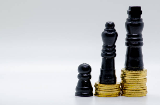 istock Status and Ambition Represented by black Pawns on Golden Coins. 2185907893