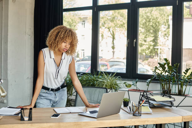 istock Professional young businesswoman engaged in work at a stylish office setting with greenery 2185908144