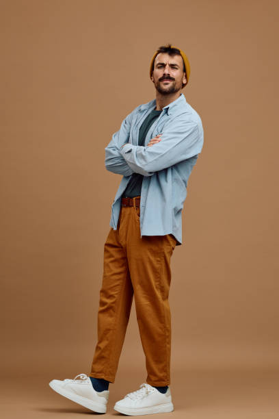 Studio shot of confident man with crossed arms looking at camera.