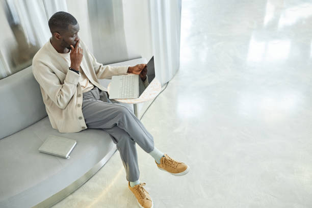 istock Concentrated Businessman Working on Laptop while Sitting at Table in Coworking Lounge Zone Indoors 2185912440