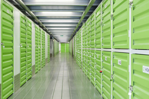 istock Warehouse Corridor with Green Doors Opening into Self Storage Units Secured with Locks 2185912475