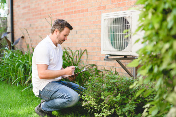 technician working on air conditioning or heat pump outdoor unit stock photo