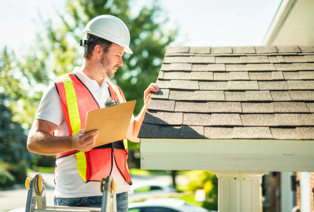 istock man with hard hat standing on steps inspecting house roof 2185914919