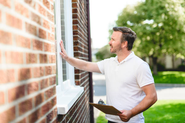 istock Man inspecting house window outside on day light 2185915549
