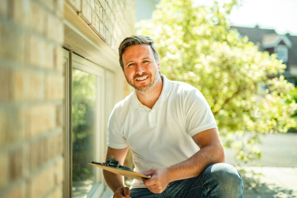 istock Man inspecting house window outside on day light 2185916172