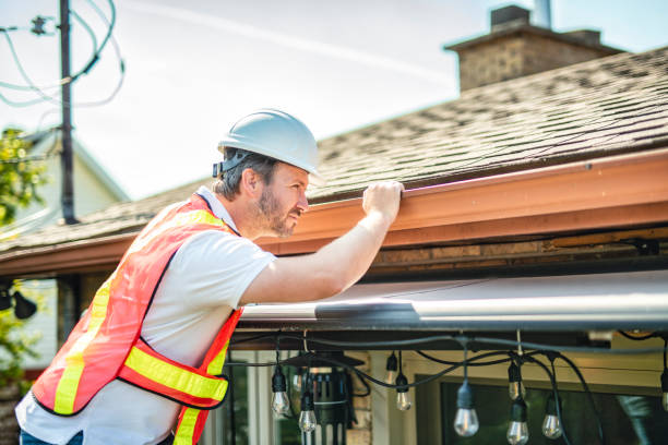 istock man with hard hat standing on steps inspecting house roof 2185916351