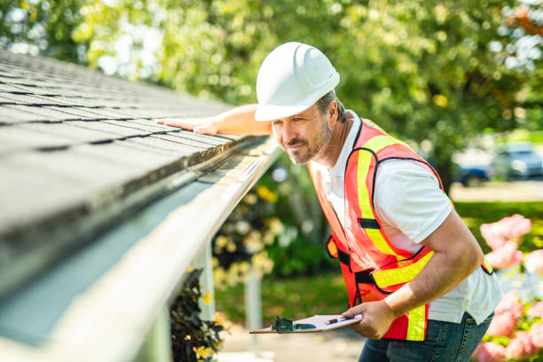 istock man with hard hat standing on steps inspecting house roof 2185916538