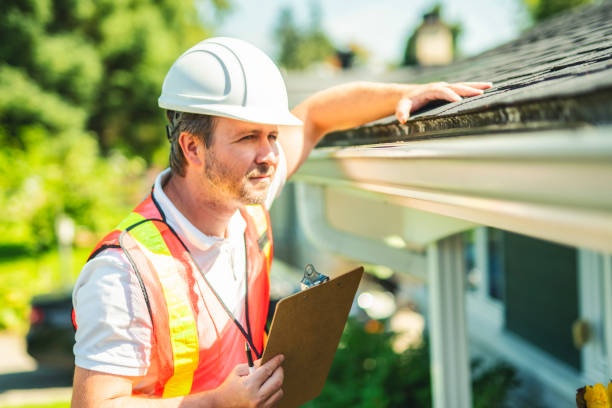 istock man with hard hat standing on steps inspecting house roof 2185916583