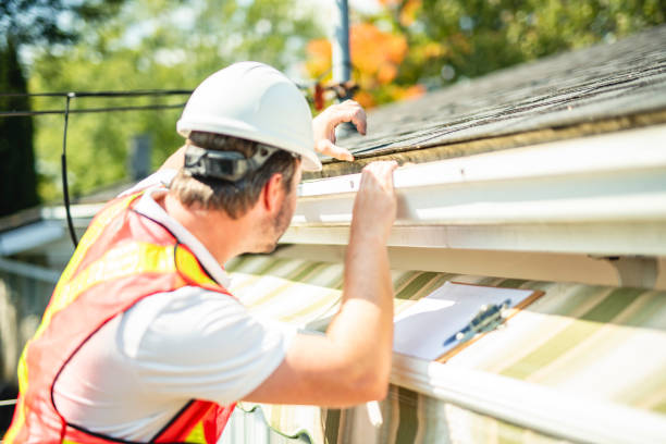 istock man with hard hat standing on steps inspecting house roof 2185917575